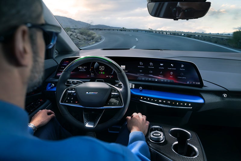 Front View of the 2026 OPTIQ-V Driving Through the Dusk Utilizing its Headlights | Spearfish Cadillac in Spearfish SD